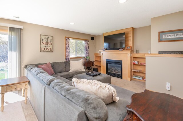 carpeted living area featuring recessed lighting and a glass covered fireplace