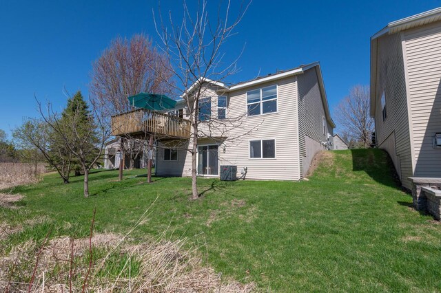 rear view of property featuring a yard, central AC, and a deck