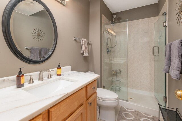full bathroom featuring vanity, tile patterned flooring, a stall shower, and toilet
