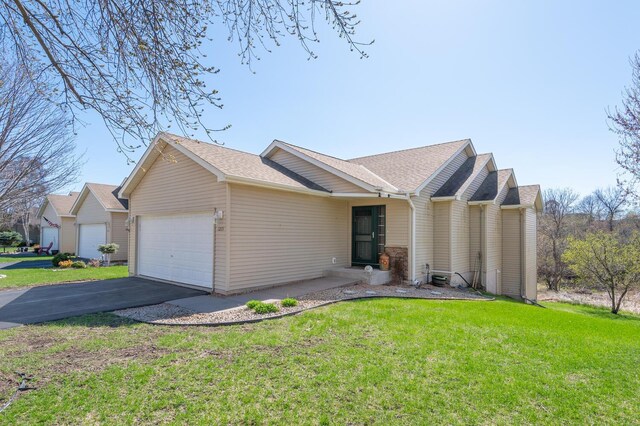 ranch-style house featuring a shingled roof, an attached garage, driveway, and a front lawn
