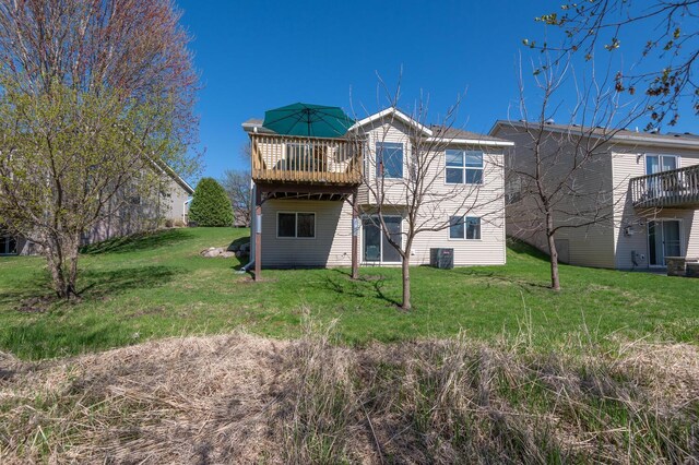 back of property with a wooden deck and a yard