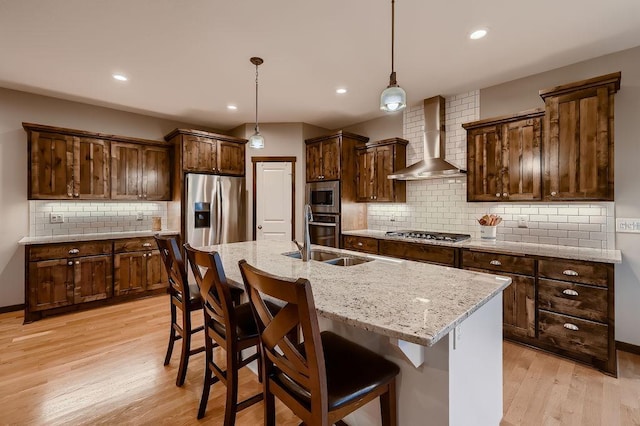 334 143rd Ave NW, Andover, MN 55304 - kitchen with wall chimney range hood, stainless steel appliances, tasteful backsplash, a sink, and light wood finished floors