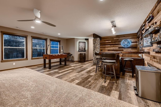 334 143rd Ave NW, Andover, MN 55304 - recreation room featuring a bar, wood finished floors, baseboards, wood walls, and a ceiling fan