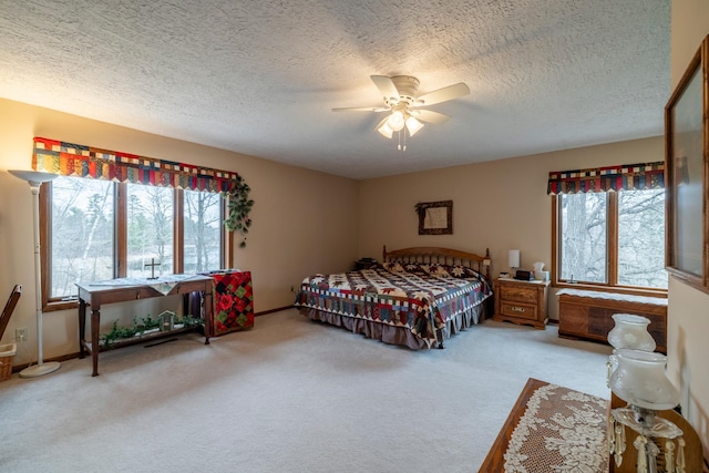 bedroom featuring baseboards, ceiling fan, carpet floors, and a textured ceiling
