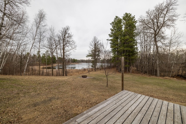 wooden terrace featuring a lawn and a water view