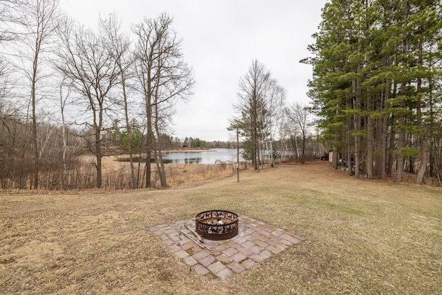 view of yard with a fire pit and a water view