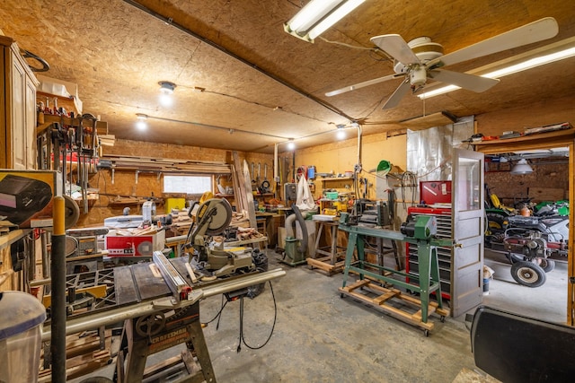 miscellaneous room with a workshop area, a ceiling fan, and unfinished concrete flooring