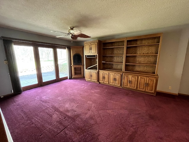 unfurnished living room with a textured ceiling, ceiling fan, dark colored carpet, and baseboards