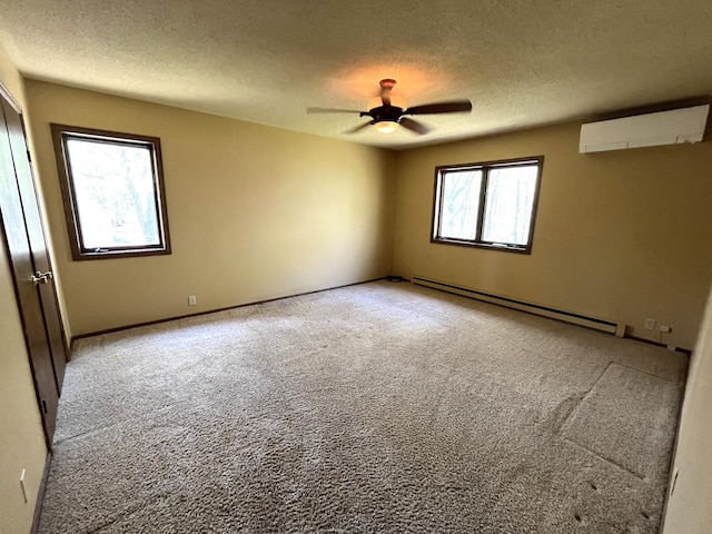 spare room with a baseboard radiator, an AC wall unit, a textured ceiling, light colored carpet, and a ceiling fan