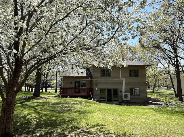 back of property with a deck, a lawn, and ac unit