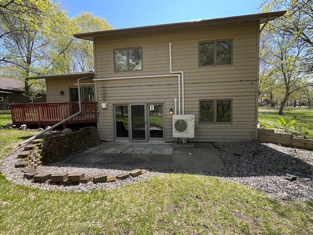 rear view of property featuring a wooden deck, a patio, a cooling unit, and a lawn