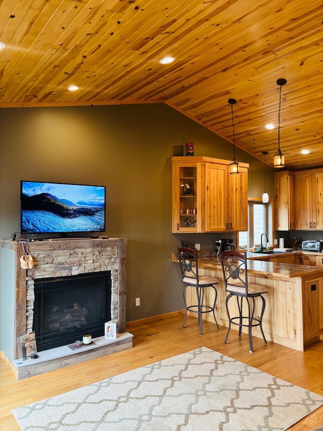 1008 Ruby St NW, Alexandria, MN 56308 - kitchen featuring wooden ceiling, lofted ceiling, a breakfast bar area, light wood-style floors, and glass insert cabinets
