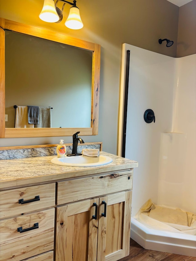 1008 Ruby St NW, Alexandria, MN 56308 - bathroom with a stall shower, vanity, and wood finished floors