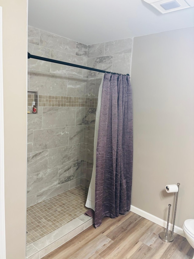 1008 Ruby St NW, Alexandria, MN 56308 - full bath with a tile shower, wood finished floors, toilet, and baseboards