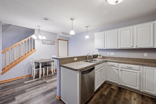 kitchen featuring dark wood finished floors, dishwasher, a sink, white cabinets, and a peninsula