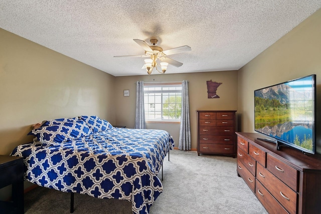 bedroom with light carpet, a ceiling fan, and a textured ceiling