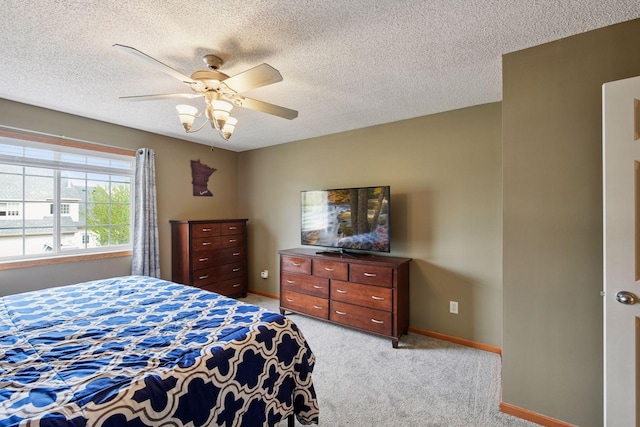 bedroom featuring baseboards, light carpet, a ceiling fan, and a textured ceiling