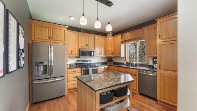 kitchen featuring hanging light fixtures, open shelves, appliances with stainless steel finishes, a sink, and light wood-type flooring