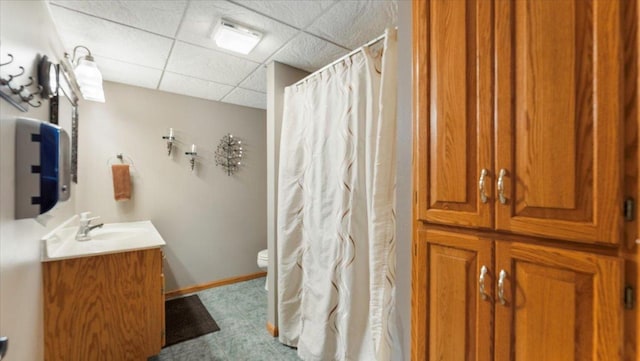 full bath featuring curtained shower, toilet, vanity, and a drop ceiling