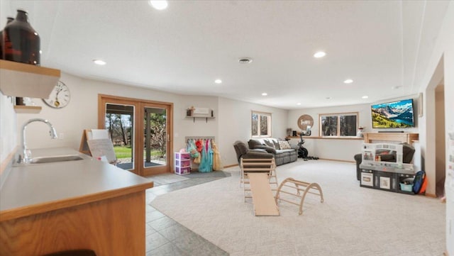 tiled living room with recessed lighting, plenty of natural light, french doors, and a sink