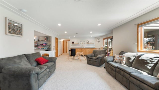 living area with recessed lighting, ornamental molding, and light carpet