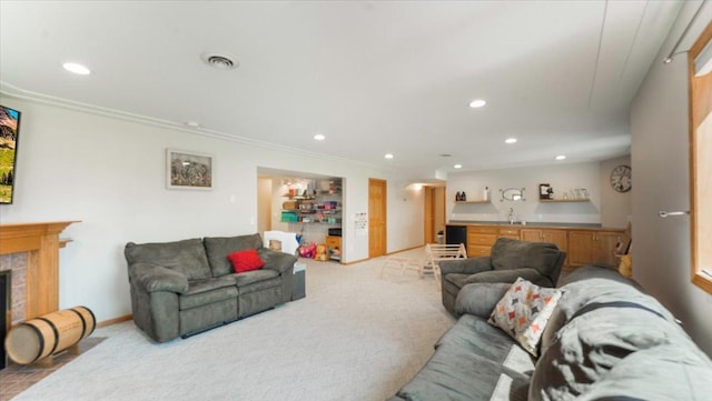 carpeted living room featuring recessed lighting, indoor wet bar, a sink, baseboards, and visible vents