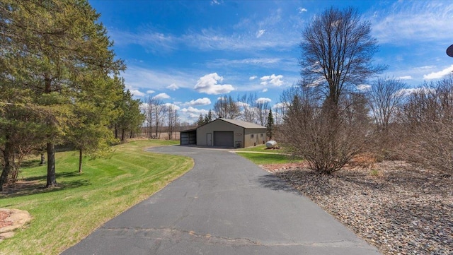 view of front of house with an outdoor structure, a front lawn, and a garage