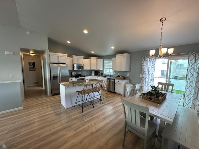 6054 59th St S, Fargo, ND 58104 - kitchen featuring a breakfast bar, a center island, white cabinetry, a notable chandelier, and stainless steel appliances
