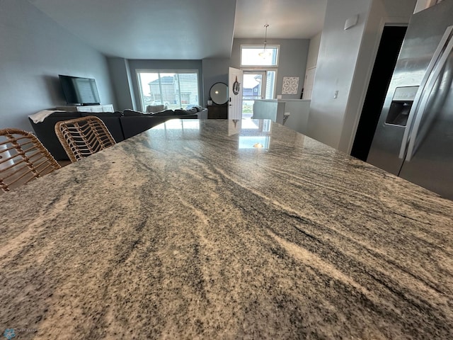 6054 59th St S, Fargo, ND 58104 - kitchen featuring dark stone counters, open floor plan, and stainless steel fridge