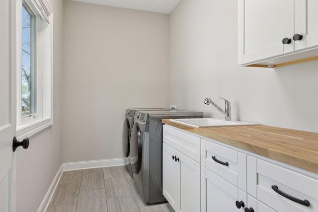 1929 Fagerness Point Rd, Orono, MN 55391 - clothes washing area featuring cabinet space, washer and clothes dryer, baseboards, and a sink