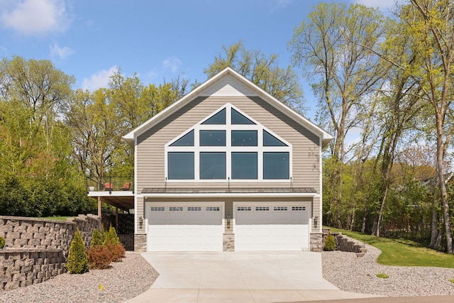 1929 Fagerness Point Rd, Orono, MN 55391 - view of front of house with an attached garage, stone siding, driveway, and a standing seam roof