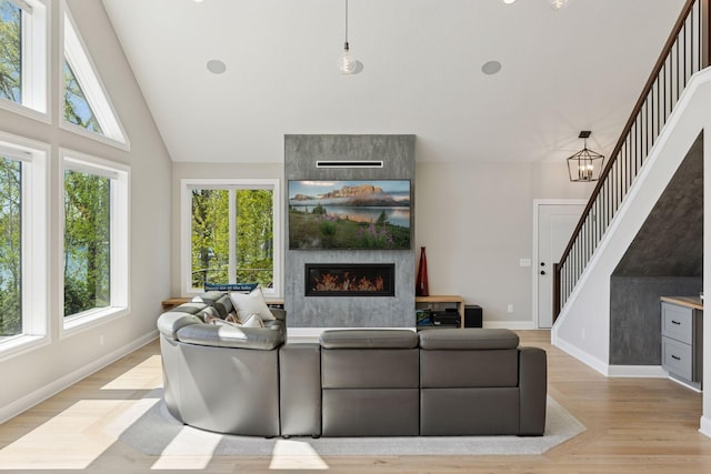 1929 Fagerness Point Rd, Orono, MN 55391 - living area featuring stairs, a fireplace, light wood finished floors, baseboards, and high vaulted ceiling