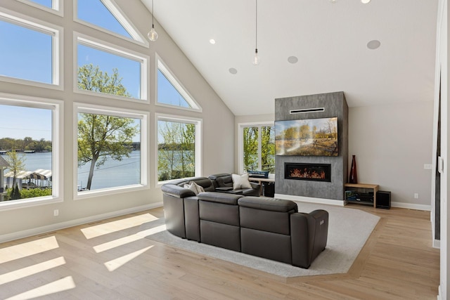 1929 Fagerness Point Rd, Orono, MN 55391 - living room featuring high vaulted ceiling, a water view, baseboards, light wood finished floors, and a fireplace