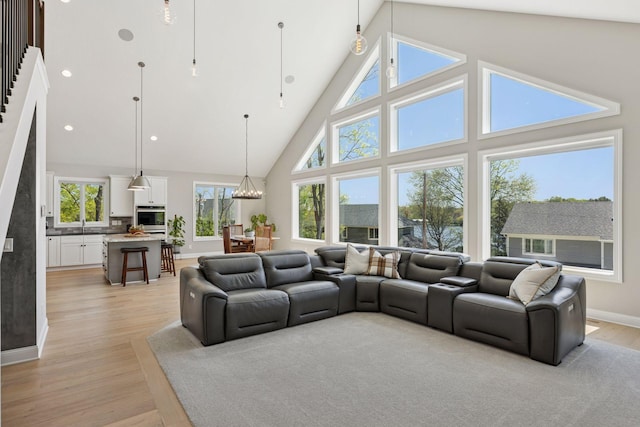 1929 Fagerness Point Rd, Orono, MN 55391 - living area with high vaulted ceiling, a chandelier, light wood finished floors, and baseboards