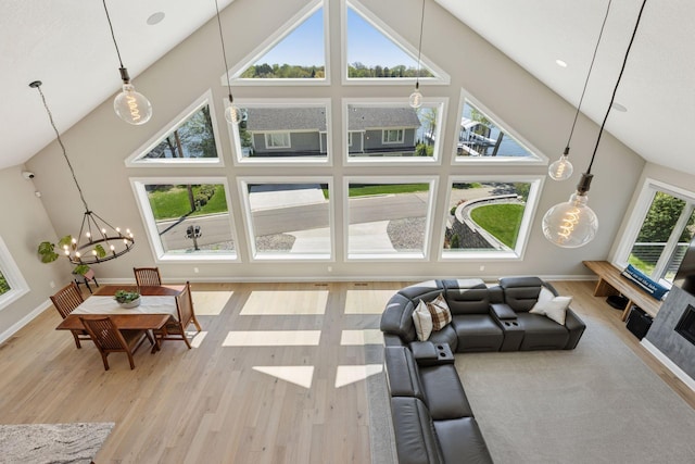 1929 Fagerness Point Rd, Orono, MN 55391 - living area with high vaulted ceiling, wood finished floors, a chandelier, and baseboards