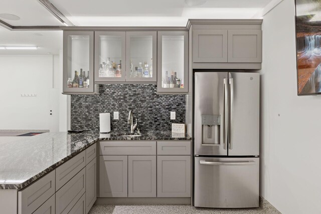 1929 Fagerness Point Rd, Orono, MN 55391 - kitchen featuring stainless steel refrigerator with ice dispenser, gray cabinets, stone counters, glass insert cabinets, and a sink