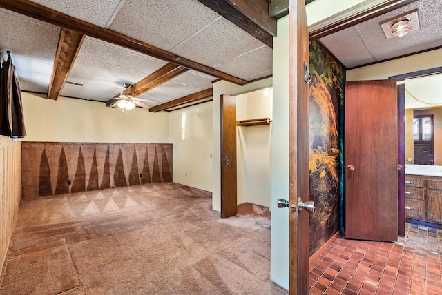 basement with ceiling fan and carpet