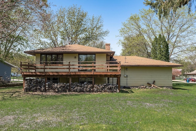 back of property with a wooden deck, a chimney, and a lawn