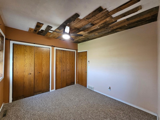 12405 State Highway 91, Leota Twp, MN 56155 - unfurnished bedroom featuring multiple closets, carpet flooring, and a ceiling fan