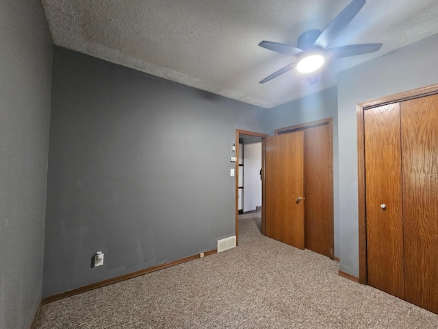 12405 State Highway 91, Leota Twp, MN 56155 - unfurnished bedroom featuring carpet floors, multiple closets, ceiling fan, and a textured ceiling