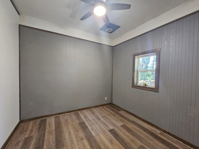 12405 State Highway 91, Leota Twp, MN 56155 - spare room featuring wood finished floors, a ceiling fan, and wooden walls