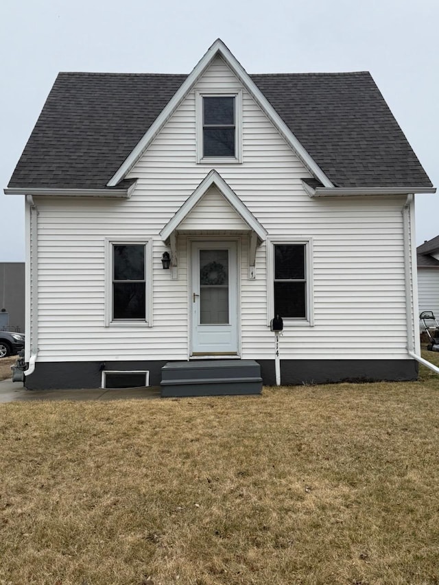 bungalow with a shingled roof and a front yard