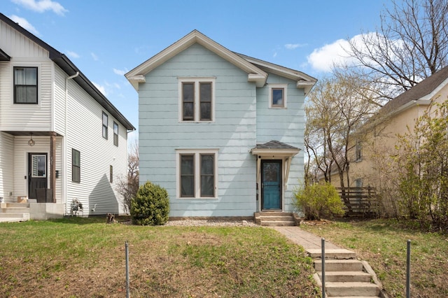 traditional-style house with fence, a front yard, and entry steps