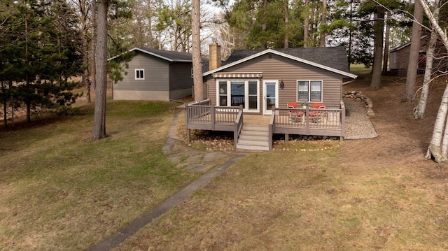 rear view of house featuring a deck and a lawn