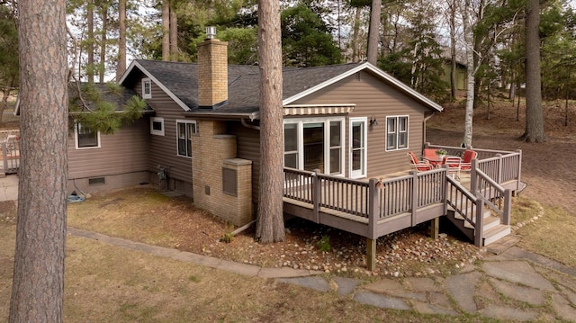 back of house with roof with shingles, a deck, a chimney, and crawl space