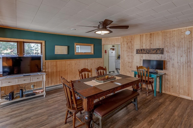 dining space with wooden walls, wood finished floors, ceiling fan, a wainscoted wall, and baseboards
