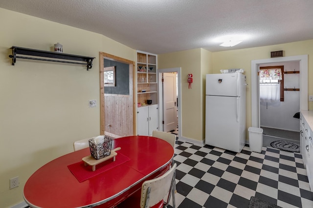 dining room with tile patterned floors and a textured ceiling