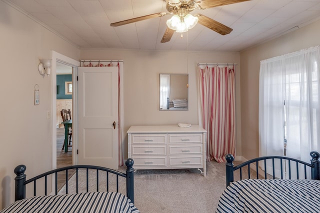 bedroom featuring carpet, a ceiling fan, and ornamental molding