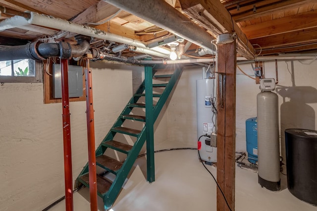 basement featuring water heater, stairs, and a water softener