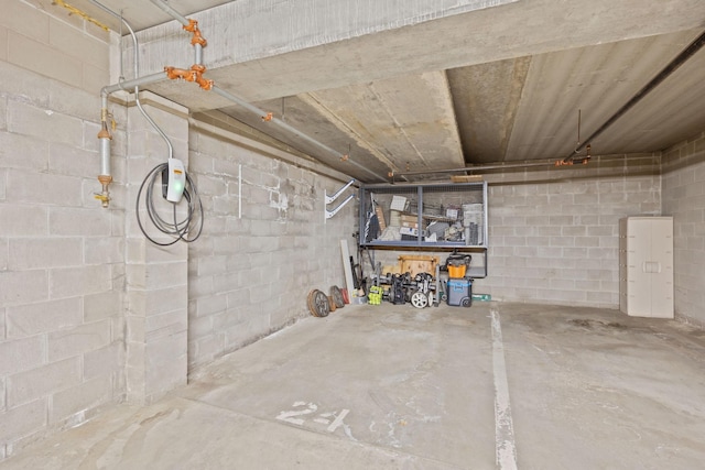 below grade area featuring a garage and concrete block wall